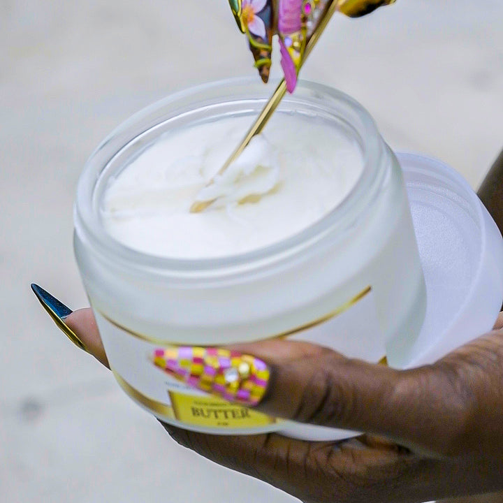 Gold scoop lifting body butter from an open jar